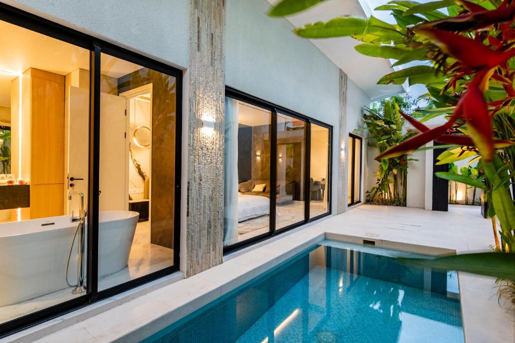 a bathroom with a swimming pool and a bath tub and a bath tub at Anoya Boutique Villa in Kerobokan
