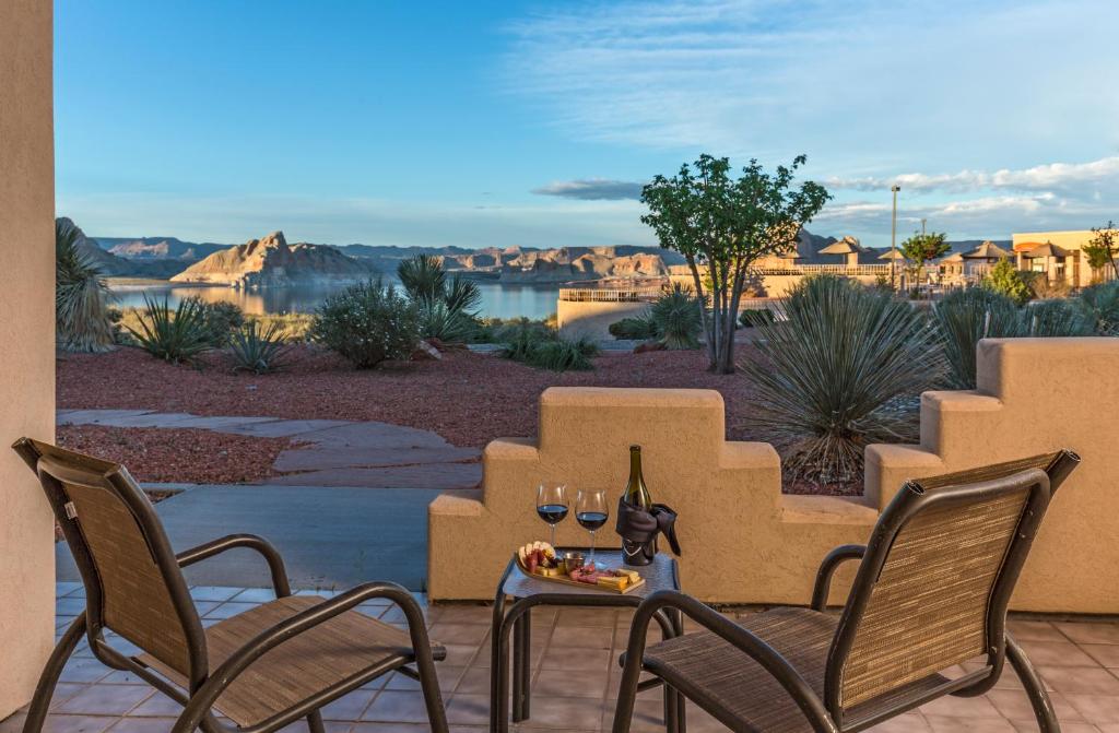 eine Terrasse mit Stühlen und einem Tisch mit Weingläsern in der Unterkunft Lake Powell Resort in Page
