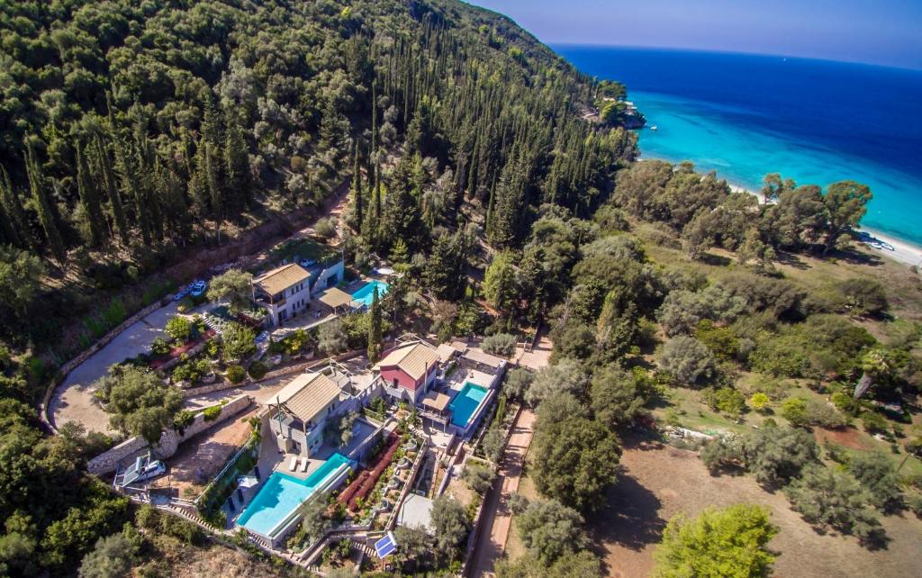 uma vista aérea de uma casa numa colina junto ao oceano em Arenaria L. Villas Complex em Lefkada