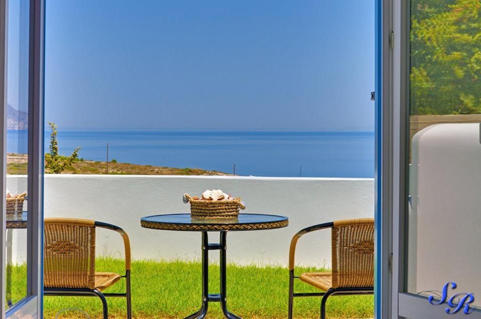 a table with a basket on it with two chairs at Sarakiniko Rooms in Adamantas