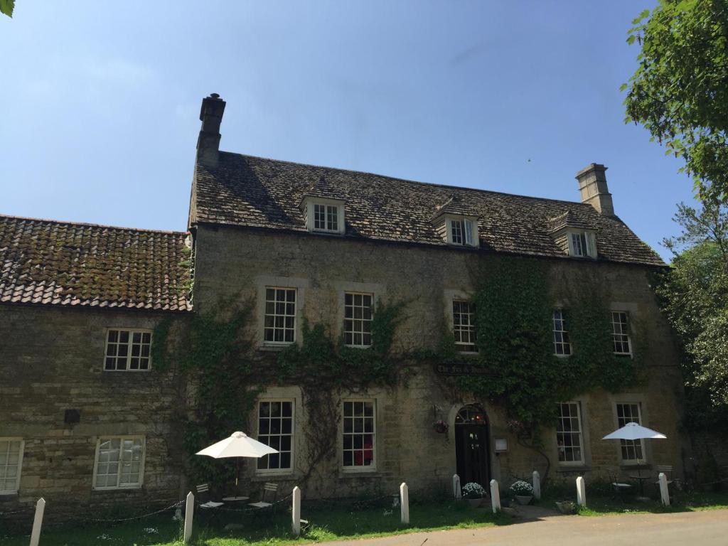 un vecchio edificio in pietra con sopra edera di The Fox and Hounds a Oakham