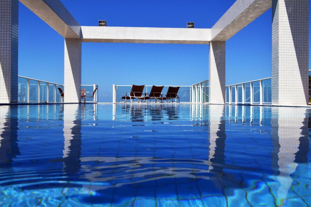 uma piscina com cadeiras no telhado de um edifício em Val Atlantic Hotel em João Pessoa