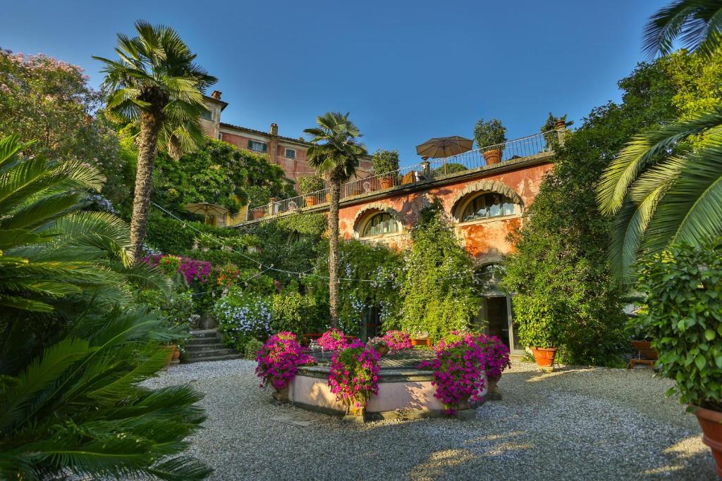 um edifício com plantas e flores num quintal em Hotel Villa Sermolli em Borgo a Buggiano