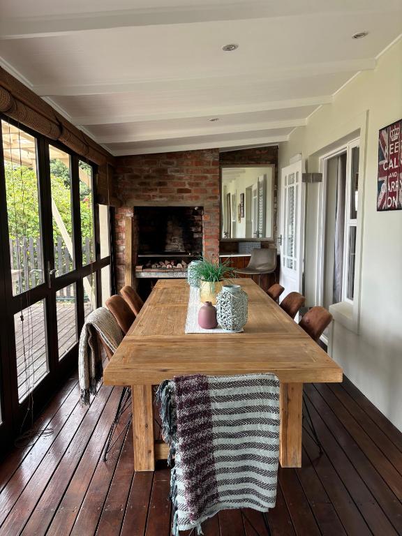 a dining room with a wooden table and a fireplace at Hakuna Matata Sedge in Sedgefield