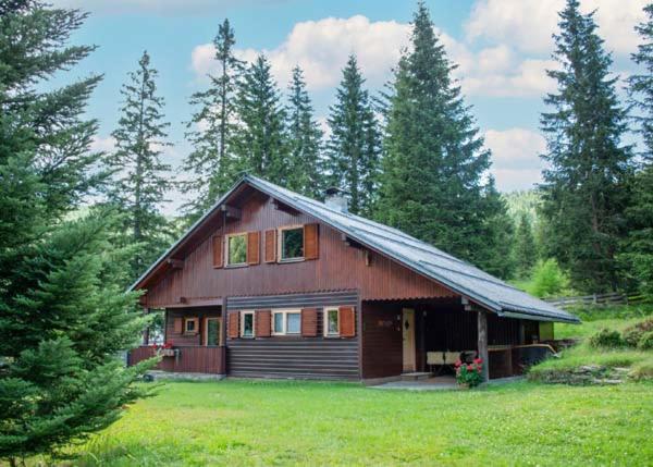 a large wooden house in the middle of a field at Almhütte Tamberger in der Feldpann-Alm in Rauth