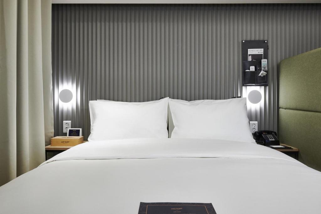 a bedroom with a large bed with two white pillows at Just Sleep Hotel Jihaeng Station in Tongduch'ŏn