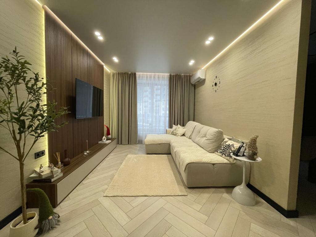 a living room with a couch and a tv at Апартаменти Оливкова симфонія in Zhytomyr