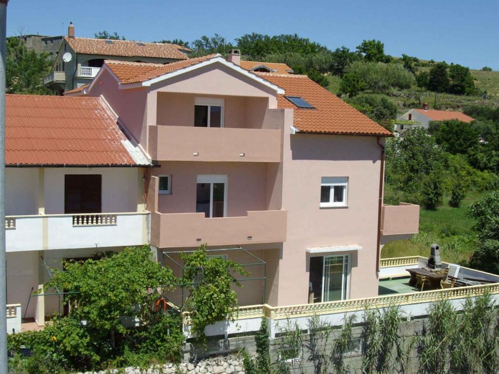 a large pink house on top of a hill at Apartment in Lopar in Lopar