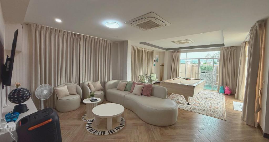 a living room with a couch and a pool table at Sea Flower Onsen in Ban Bo Khaem