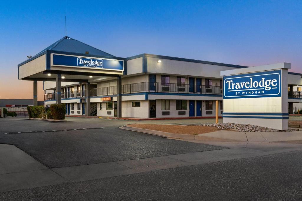 a large building with a sign for a hotel at Travelodge by Wyndham Albuquerque West in Albuquerque