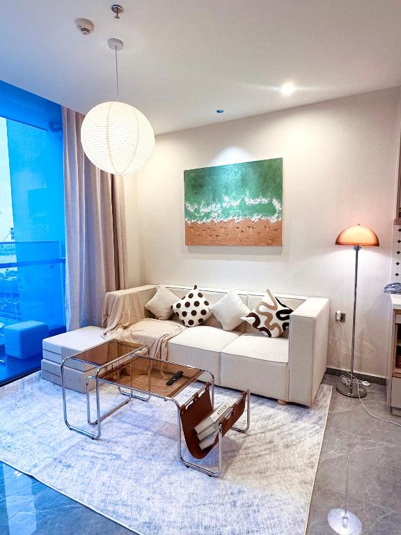 a living room with a white couch and a table at ICON40 Homestay Hạ Long - Ocean View in Ha Long