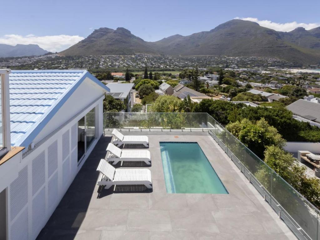 a view of a house with a swimming pool and chairs at Villa Mykonos in Cape Town