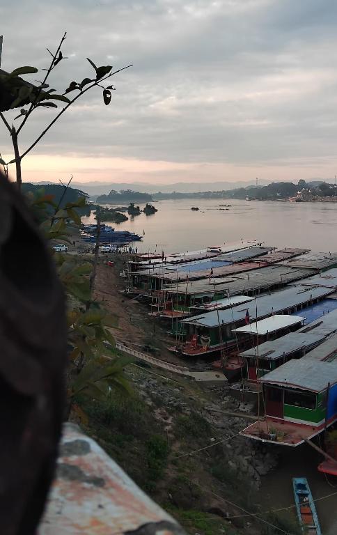 a group of boats parked on the shore of a river at Phonevichith Riverside Hotel Houayxai in Ban Khonkèo