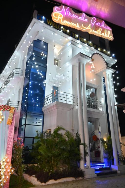 a large white building with a neon sign on it at Nirmala Garden in Bamiana
