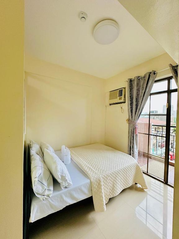a bedroom with a bed and a window at STUDIO WITH BALCONY at the HEART of DAVAO CITY in Davao City