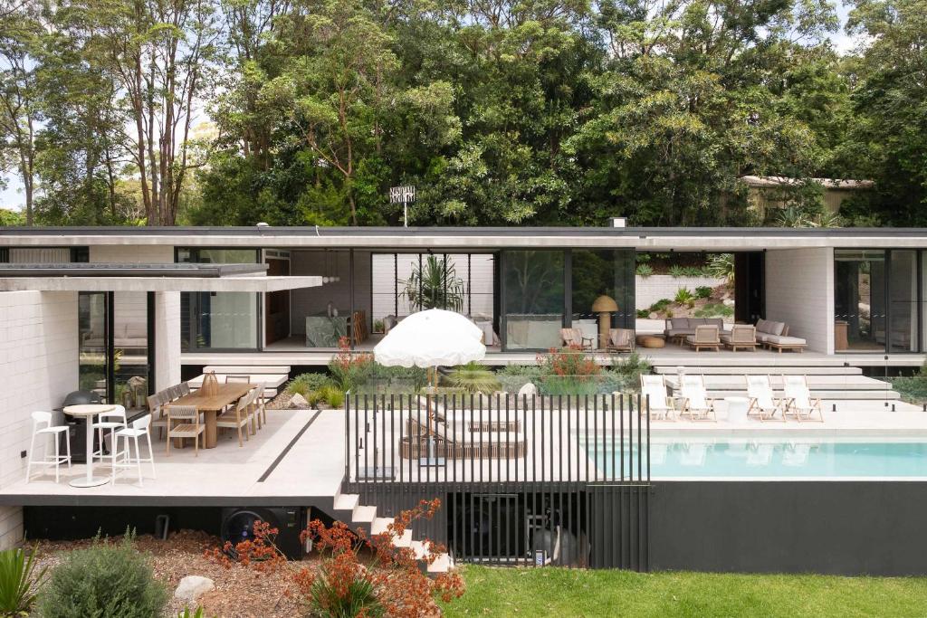 a house with a swimming pool and a patio at Latitude 156 - Elevated Luxury Overlooking the Greens in Doonan