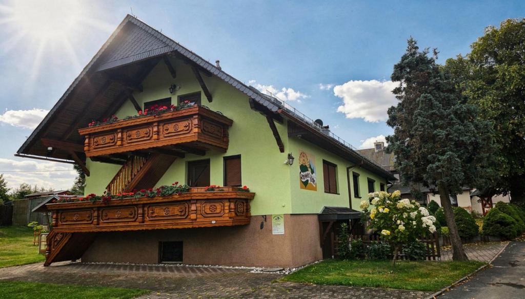 a house with a balcony with flowers on it at Ferienhaus Richter in Drognitz