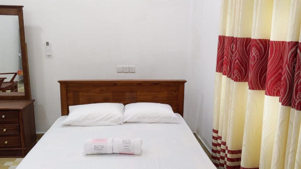 a bedroom with a bed with two towels on it at Villa Rashel in Nikawatawana