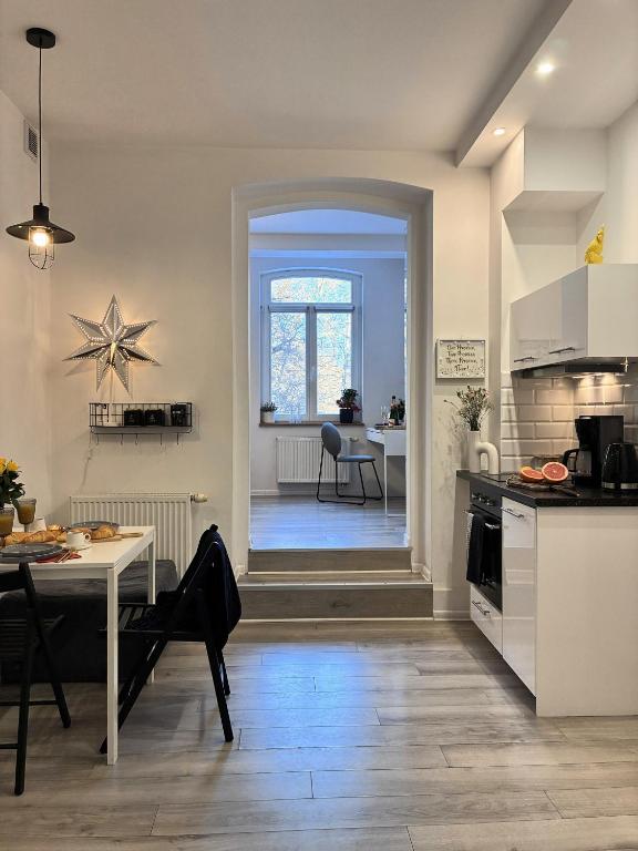 a kitchen and living room with a table and a dining room at Apartament 100m od morza in Sopot