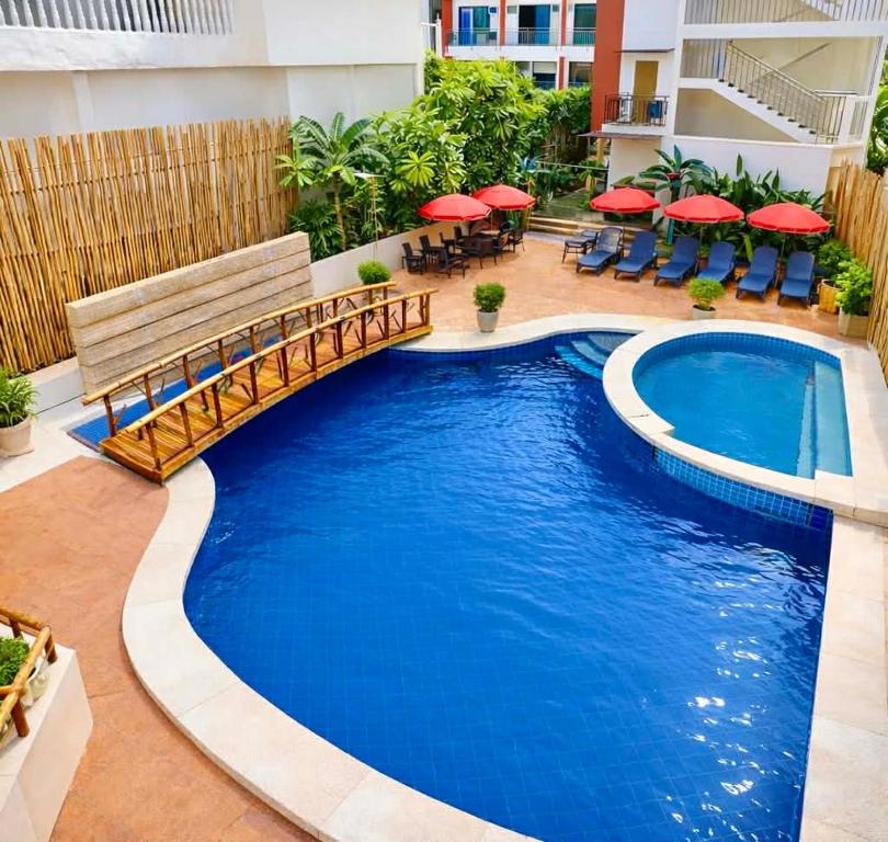 a pool with a wooden bridge and a bench at Red Coco Inn de Boracay in Boracay