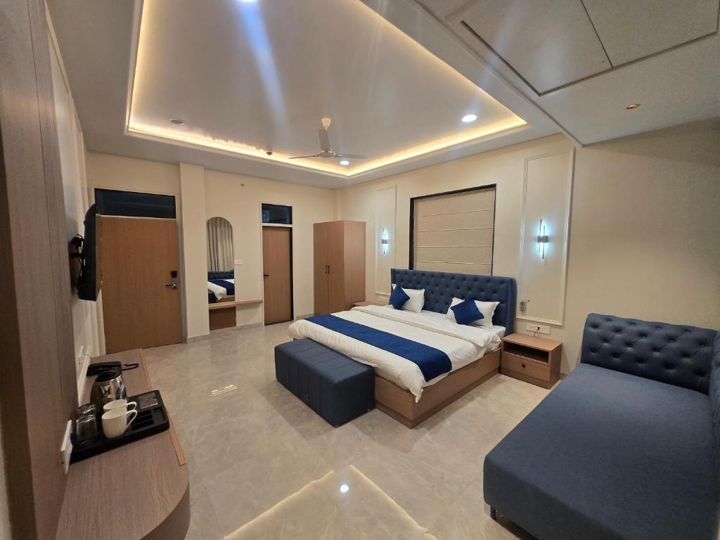 a bedroom with a bed and a couch and a chair at Hotel Shree Karni Palace in Kishangarh