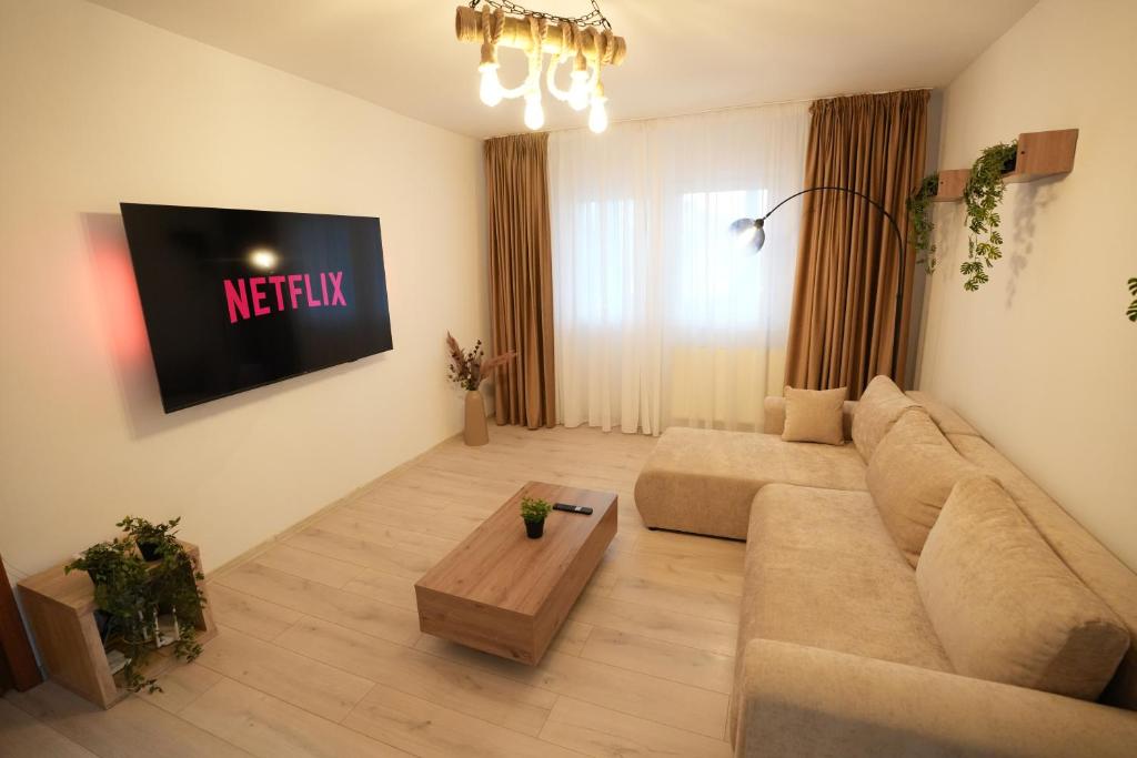 a living room with a couch and a tv at Lumena - Kingsize Beds, ultracentral, 80mp in Topliţa