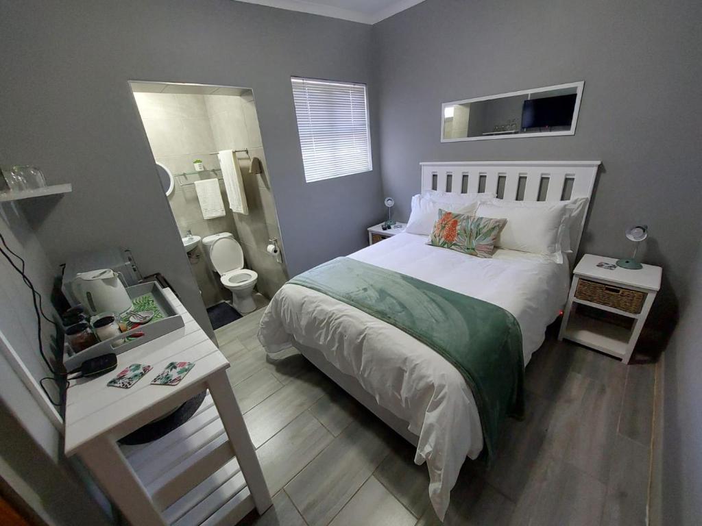 a small bedroom with a bed and a bathroom at Stay a While Self catering - Close to Greenacres Hospital, free Wi-Fi, and secure parking in Newton Park