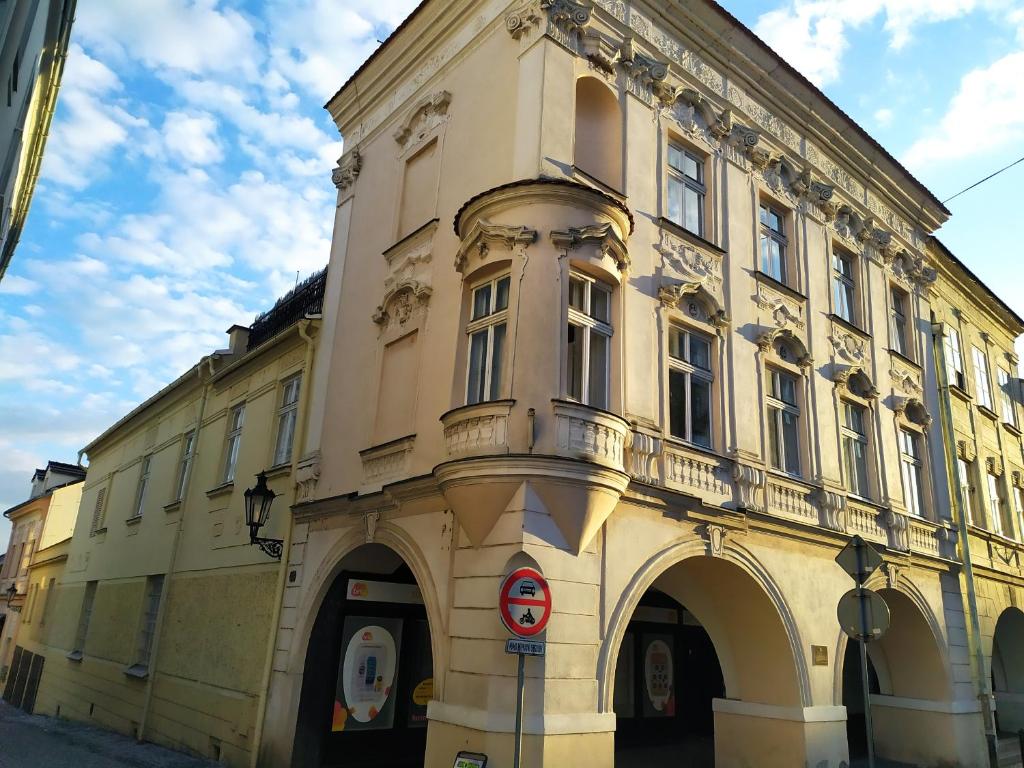 a large yellow building with arches on a street at Apartmány Šitavanc in Příbor