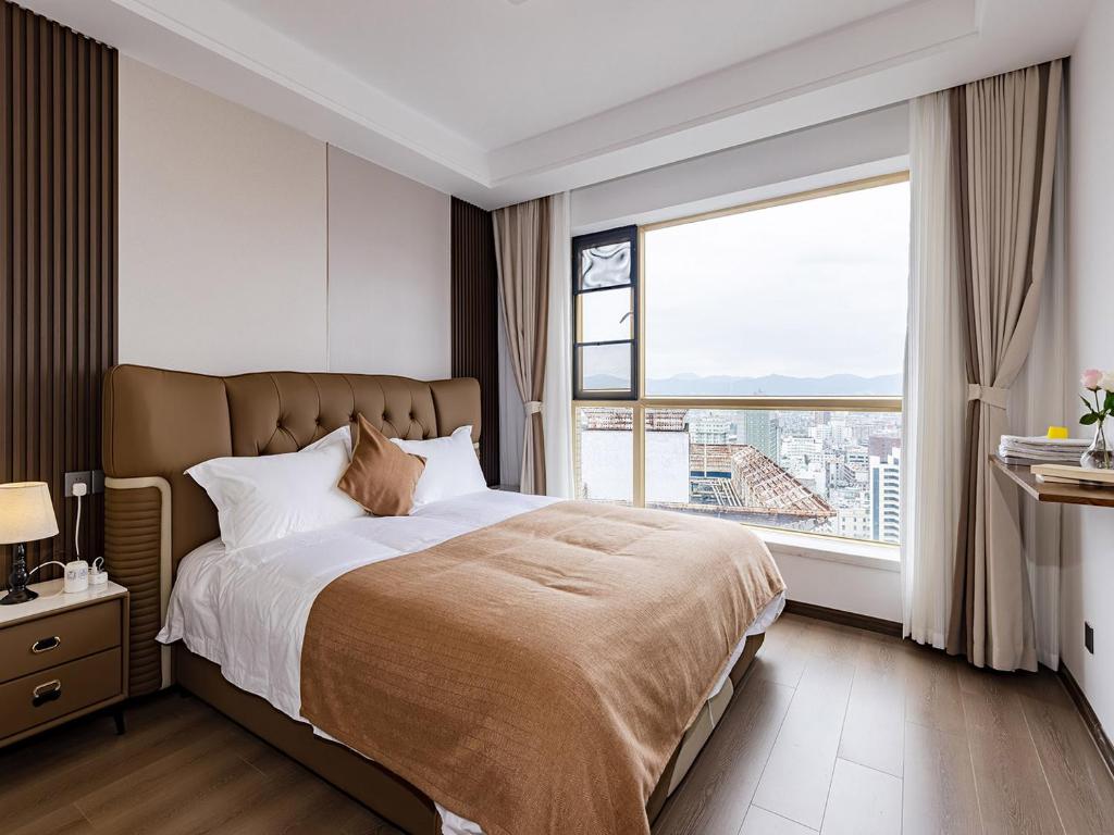 a bedroom with a large bed with a large window at Annie Apartment 3204 River View -only 120 meters from Metro Line 2 Exit of Chuanxinggulou in Kunming
