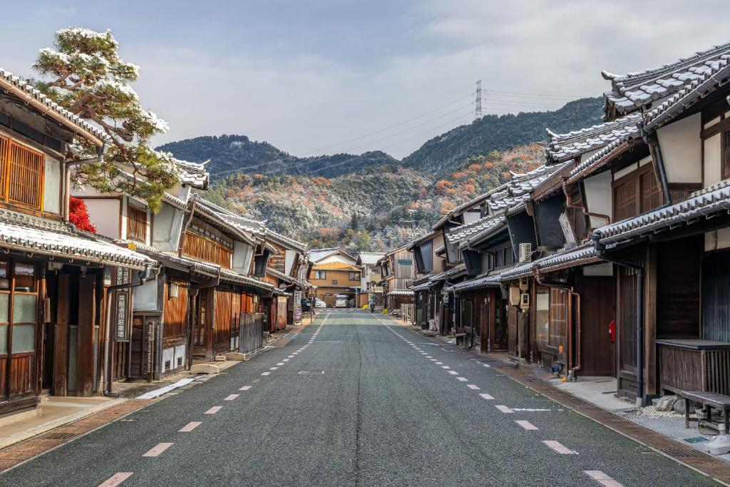 an empty street in an asian town with buildings at Machiya Hotel oyado baison in Mino