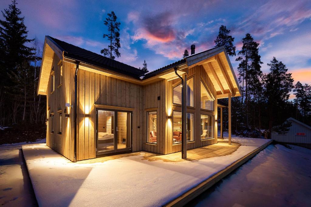 a house in the snow with lights on at Lothlórien Lodge 8p Sauna in Vradal