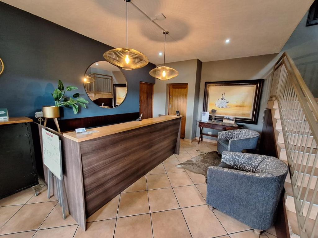 a living room with a staircase and a mirror at Kusile Guest House in Burgersfort