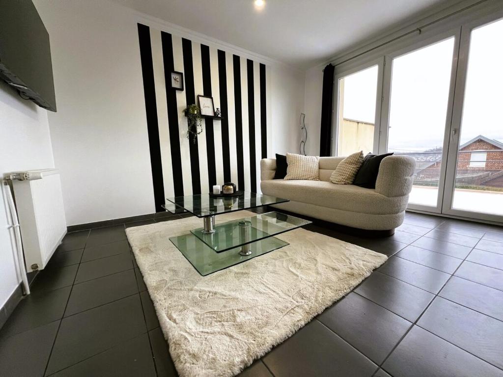 a living room with a couch and a glass table at Maison Panorama avec terrasse exposition sud in Mers-les-Bains
