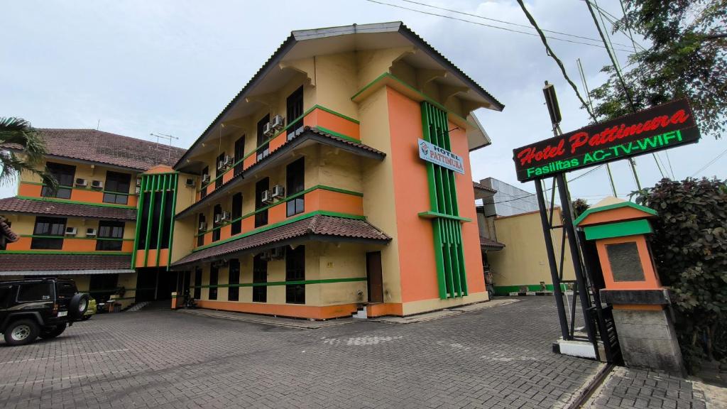 a large building with a sign in front of it at Hotel Pattimura powered by Cocotel in Stasiun Tawang