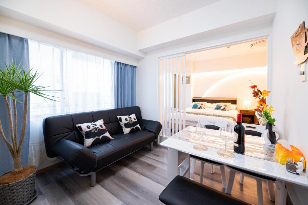 a living room with a couch and a table at Happy Osaka City in Osaka