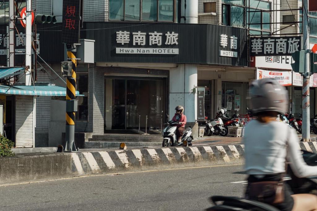 a group of people riding motorcycles down a city street at Hwa Nan Hotel in Yongkang