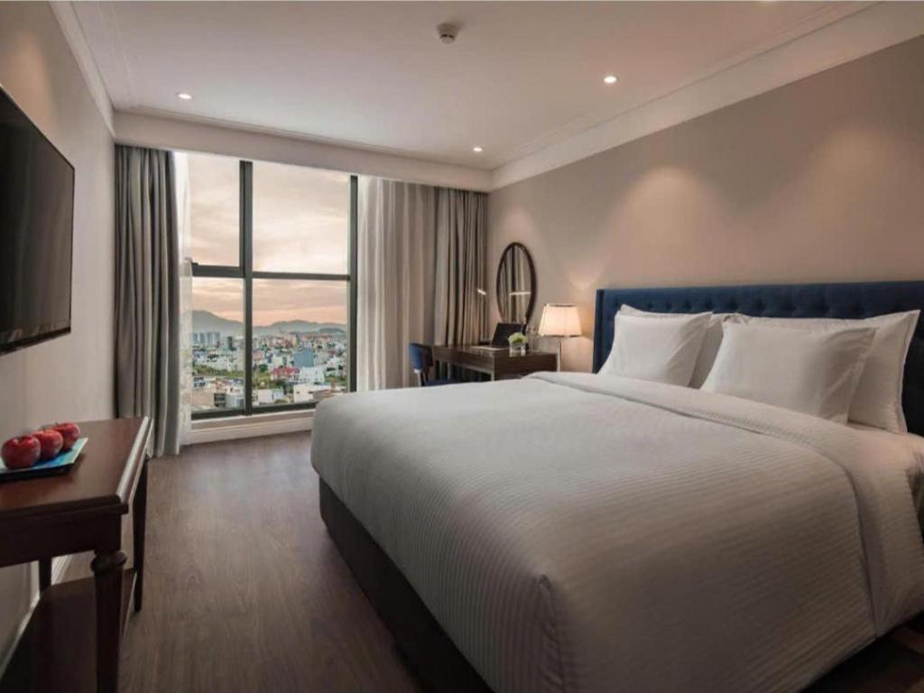 a bedroom with a large bed and a large window at DN ALT sentafe ppt in Danang