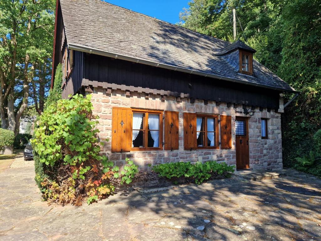 a small stone house with wooden doors and windows at Jagdhütte Breidelsley in Nideggen