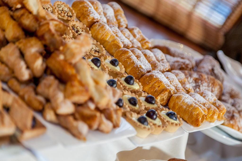 a bunch of different types of pastries on plates at Hotel Don Diego in Porto San Paolo