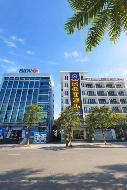 two tall buildings with a sign in front of them at Central Hotel in Móng Cái
