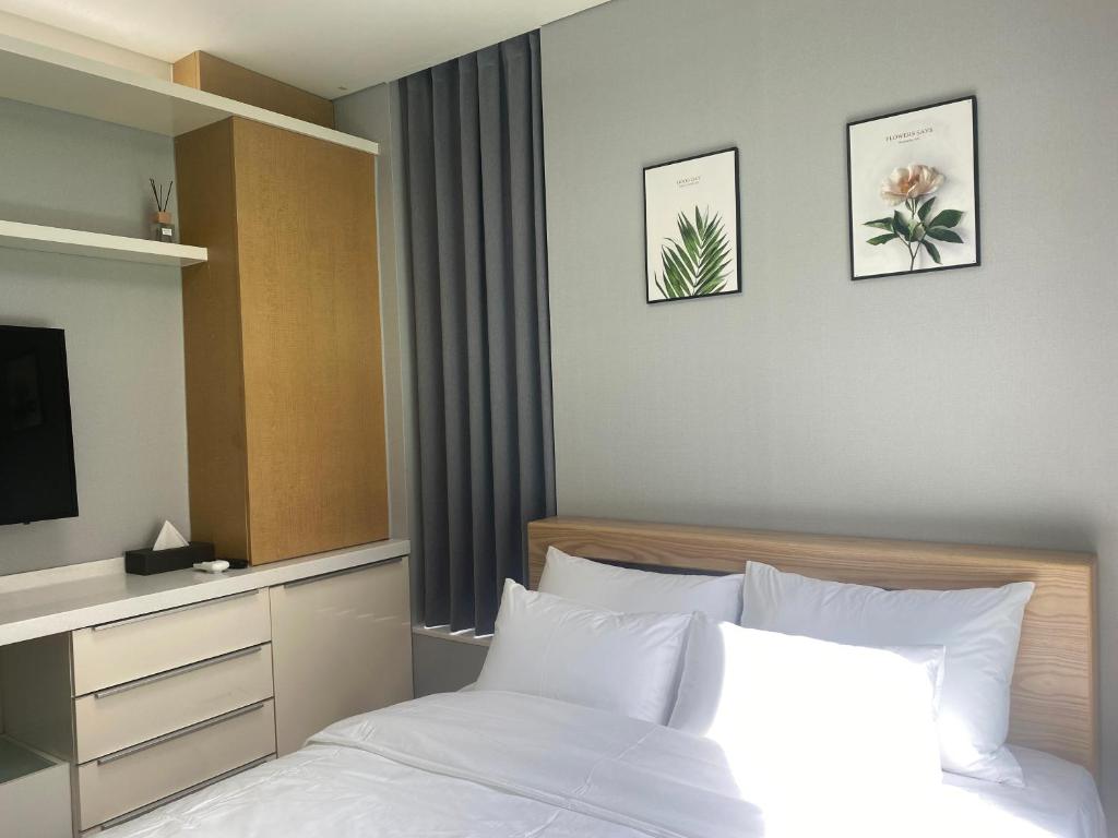 a bedroom with a bed and a tv on the wall at Sky Star in Incheon