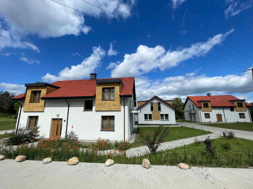 a house with a red roof on a street at Apartamenty Panoramic-Piecki in Piecki