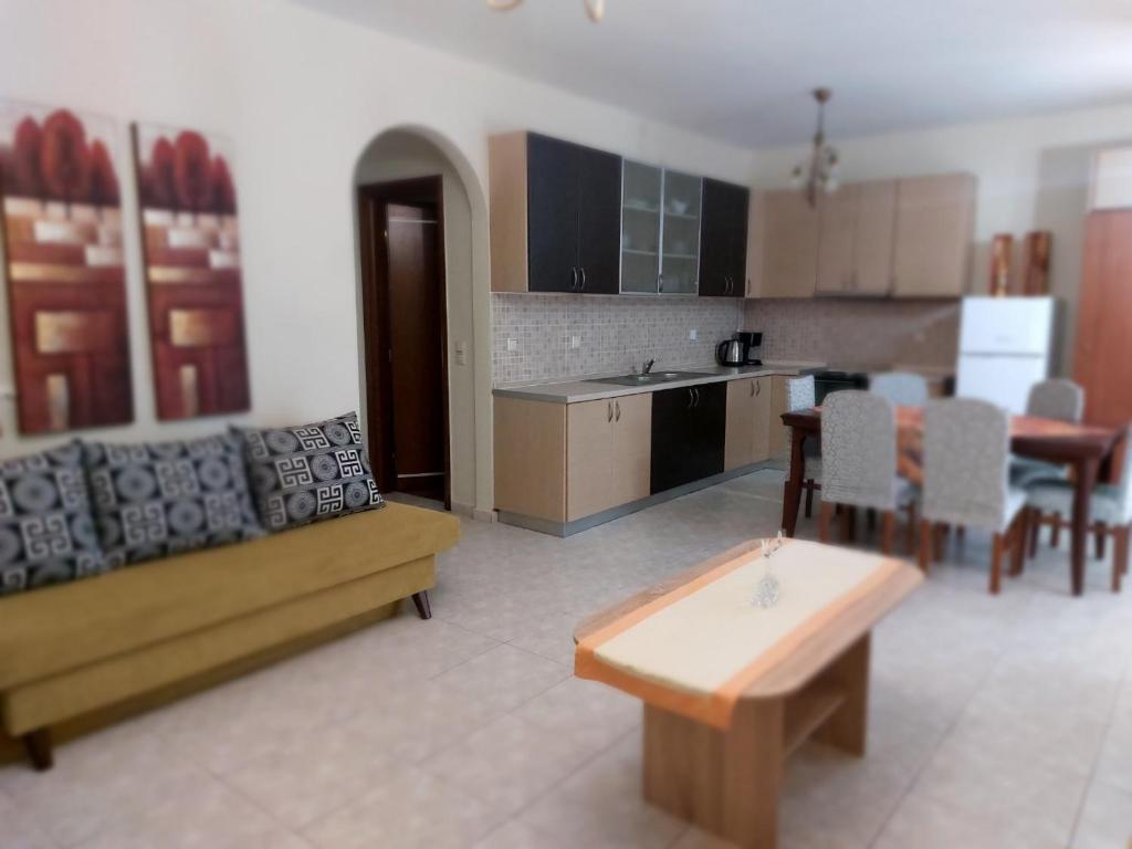 a living room with a couch and a kitchen at Hellen's Summer house in Keramoti