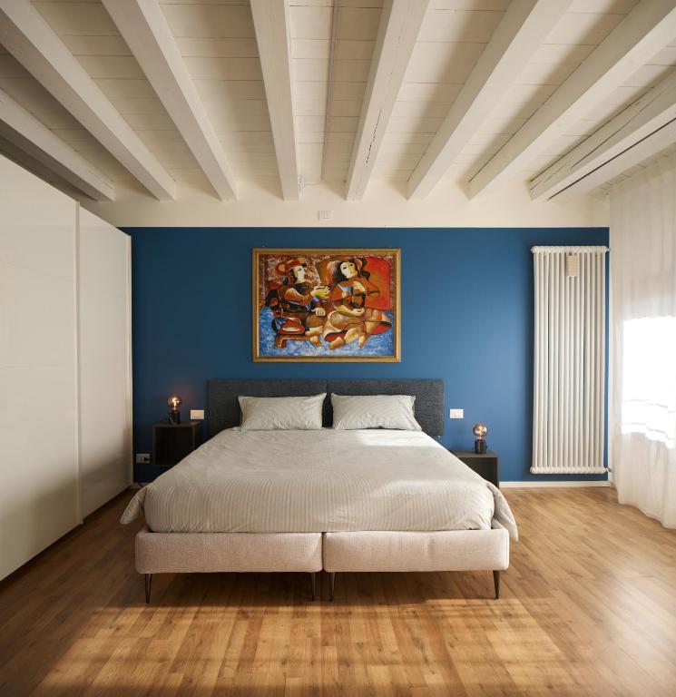 a bedroom with a large bed with a blue wall at Le Mura Minicase int 3 in Castelfranco Veneto
