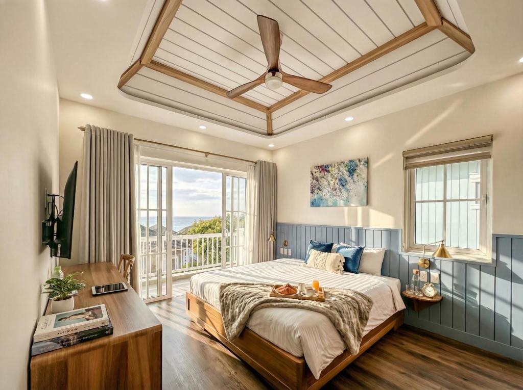 a bedroom with a large bed and a large window at Novaworld Phan Thiết - Alala Stay in Bình Sum