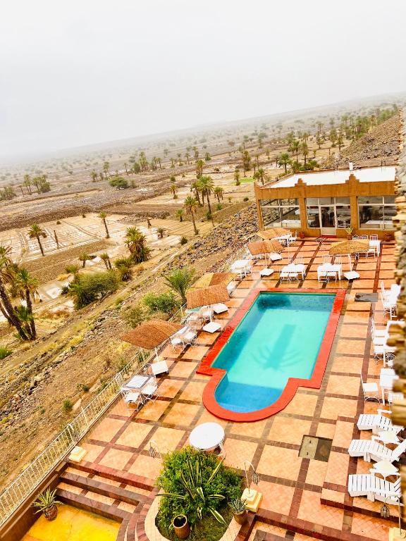a resort with a swimming pool and lounge chairs at Hotel Kasbah Ennakhile - Authentic Stay in Nkob in Nkob