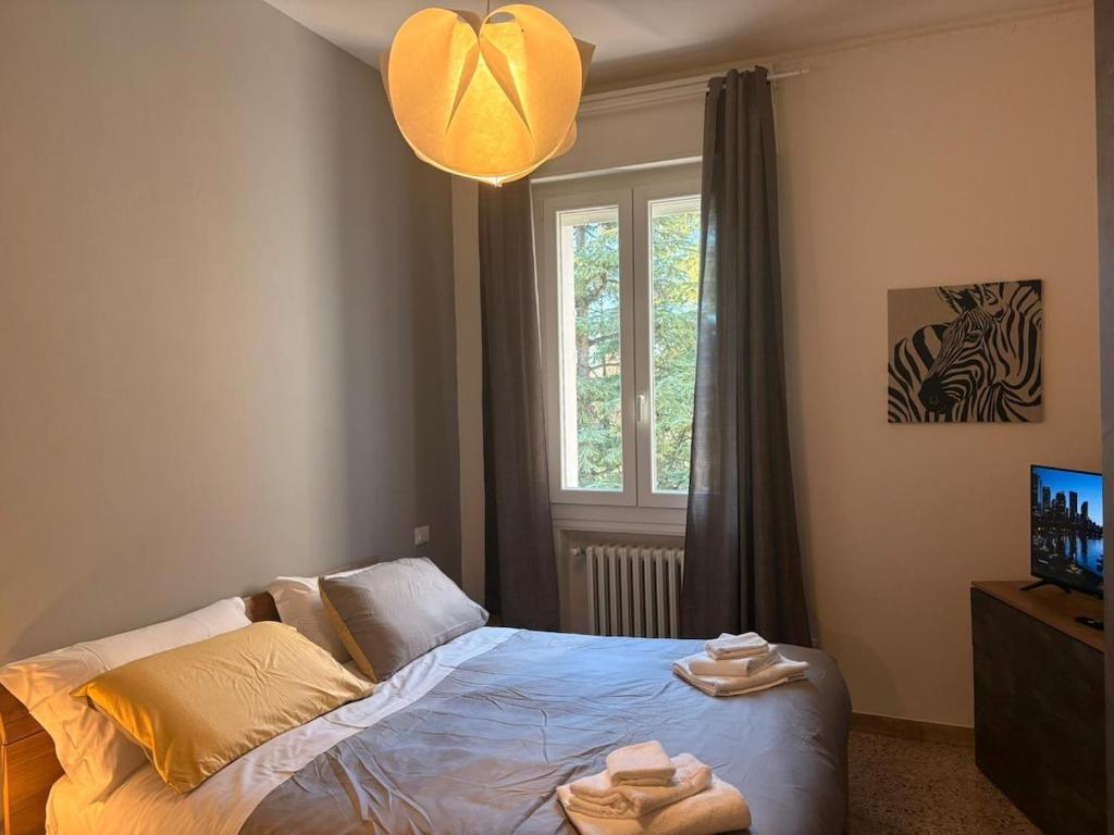 a bedroom with a bed with towels on it at GuestHouse Modena Buon Pastore in Modena