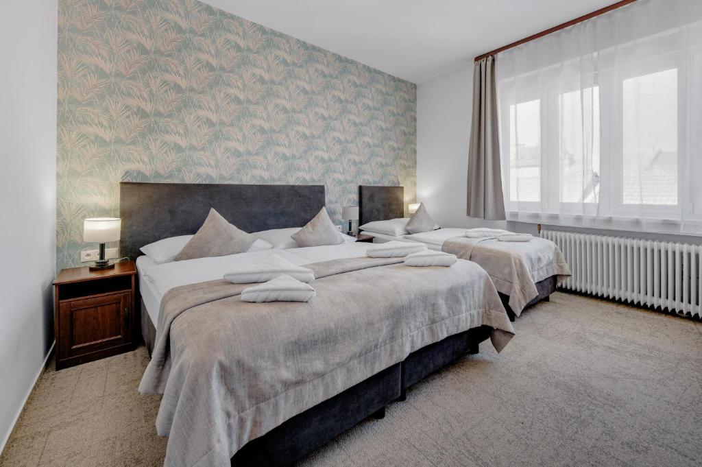 a bedroom with two beds and a large window at 7Days B&B in Bratislava