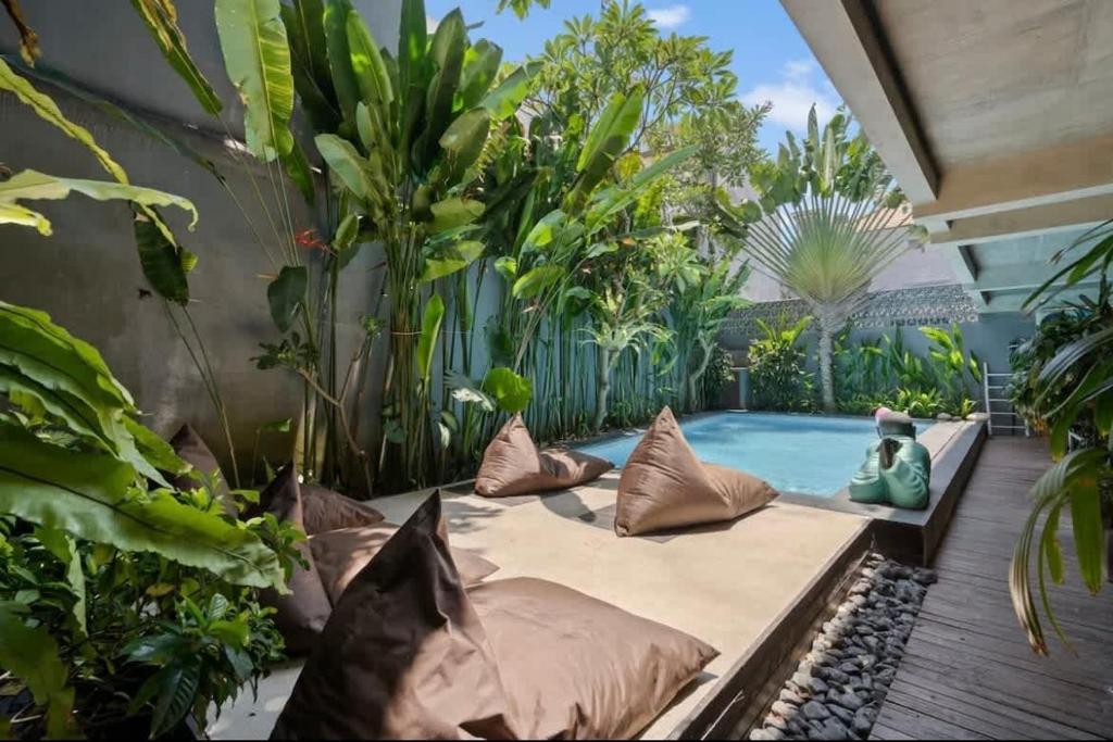 a garden with a pool and some plants at Modern Apartment with Shared Pool - By the Beach in Seminyak