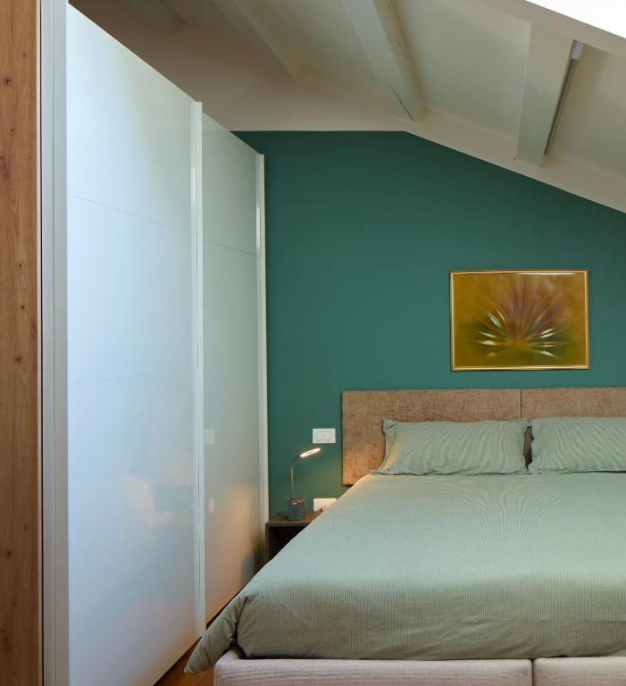a bedroom with a bed and a blue wall at Le Mura Minicase int 4 in Castelfranco Veneto